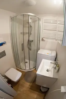 a bathroom with a shower and a toilet and a sink at Rondo Mogilskie Apartment in Kraków