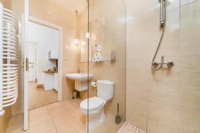 a bathroom with a toilet and a glass shower at Apartamenty w Pałacu Pod Baranami in Kraków