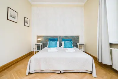 a bedroom with a large bed with blue pillows at Apartamenty w Pałacu Pod Baranami in Kraków