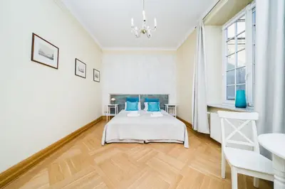 a bedroom with a bed with blue pillows at Apartamenty w Pałacu Pod Baranami in Kraków