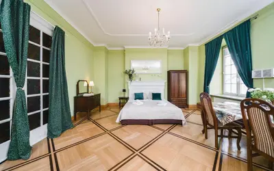 a bedroom with a bed and a table and chairs at Apartamenty w Pałacu Pod Baranami in Kraków