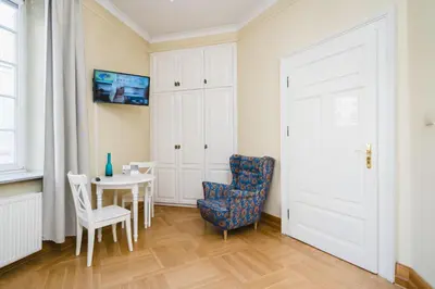 a room with a table and a chair and a door at Apartamenty w Pałacu Pod Baranami in Kraków
