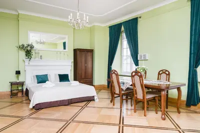 a bedroom with a bed and a table and chairs at Apartamenty w Pałacu Pod Baranami in Kraków