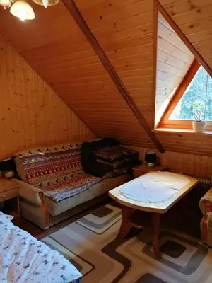 a room with a bed and a table in a attic at Góralska Czarcia Chata pod Jałowcem in Stryszawa