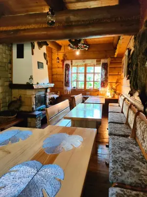 a dining room with tables and chairs in a cabin at Góralska Czarcia Chata pod Jałowcem in Stryszawa