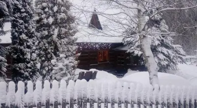 a fence in front of a house covered in snow at Góralska Czarcia Chata pod Jałowcem in Stryszawa