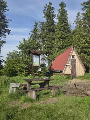 a picnic table and a barn in a field at Góralska Czarcia Chata pod Jałowcem in Stryszawa