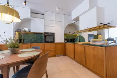 a balcony with two chairs and a glass table at City Lights Apartments in Kraków