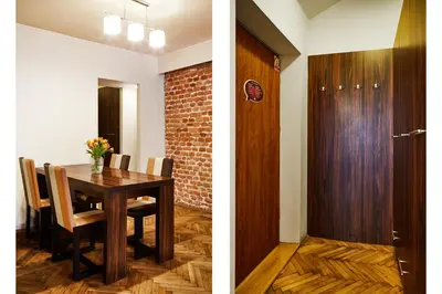 a dining room with a table and a wooden door at Krakow For You Main Square Apartments in Kraków