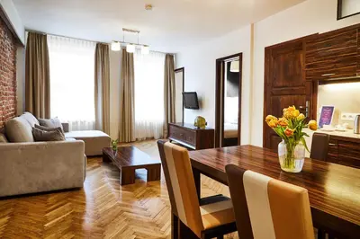 a living room with a dining room table and a couch at Krakow For You Main Square Apartments in Kraków