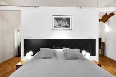 a white bedroom with a large bed with two lamps at Krakow For You Main Square Apartments in Kraków
