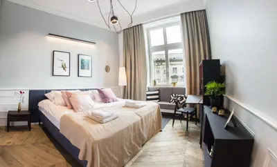 a bedroom with a large bed and a desk at Stradom15 Apartments in Kraków