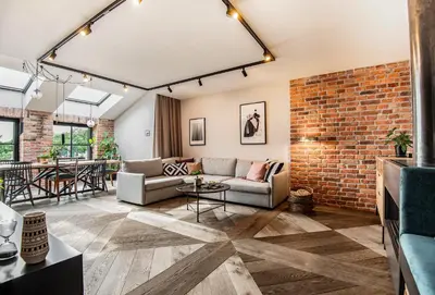 a living room with a couch and a brick wall at Stradom15 Apartments in Kraków