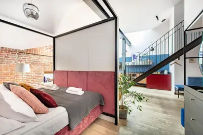 a bedroom with a bed and a brick wall at Stradom15 Apartments in Kraków