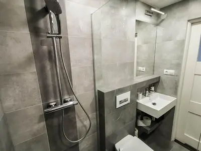 a bathroom with a shower and a toilet and a sink at Sky Apartments - Łagiewniki in Kraków