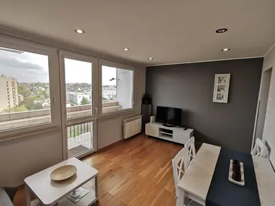 a living room with a dining table and a television at Sky Apartments - Łagiewniki in Kraków
