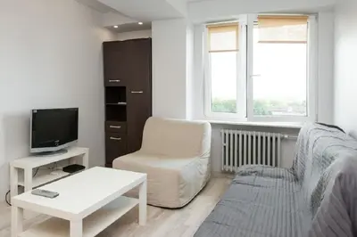 a living room with a couch and a chair and a tv at Studio Aleja Pokoju II in Kraków