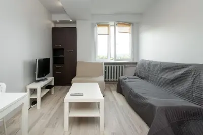 a living room with a couch and a tv at Studio Aleja Pokoju II in Kraków