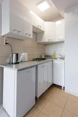a large white kitchen with white cabinets and appliances at Studio Aleja Pokoju II in Kraków