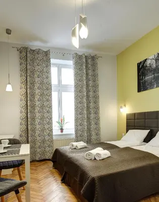 a bedroom with a bed with two towels on it at Grace Apartments in Kraków
