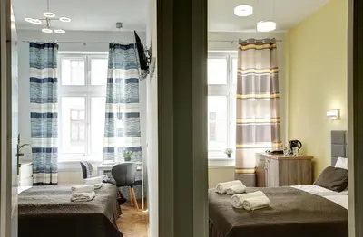 a room with two beds with towels on them at Grace Apartments in Kraków