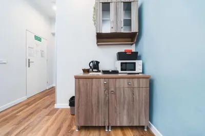 a kitchen with a microwave on top of a wooden cabinet at Grace Apartments in Kraków