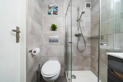 a bathroom with a toilet and a glass shower at Grace Apartments in Kraków