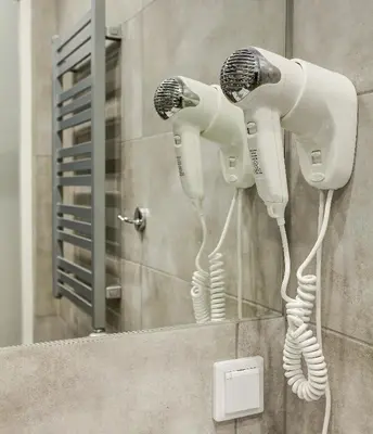 a pair of hair dryers on a wall in a bathroom at Grace Apartments in Kraków