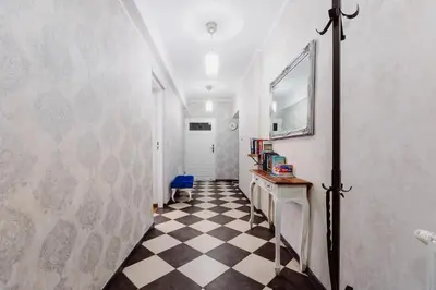 a hallway with a black and white checkered floor at Kings City - Zyblikiewicza Apartment in Kraków