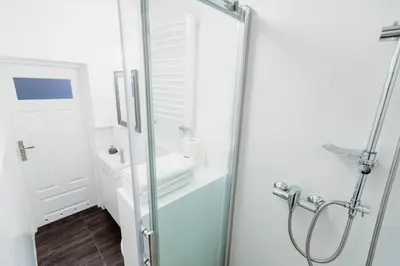 a glass shower in a bathroom with a sink at Kings City - Zyblikiewicza Apartment in Kraków