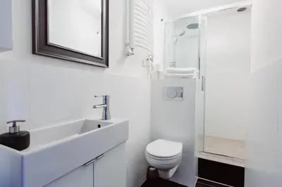 a white bathroom with a sink and a toilet at Kings City - Zyblikiewicza Apartment in Kraków