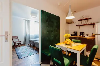 a kitchen and dining room with a table and chairs at Kings City - Zyblikiewicza Apartment in Kraków