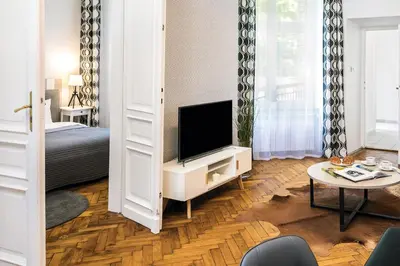 a living room with a tv and a bed and a table at Old Town Residence Bis in Kraków