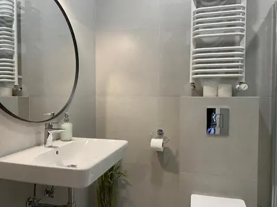 a white bathroom with a sink and a mirror at Old Town Residence Bis in Kraków