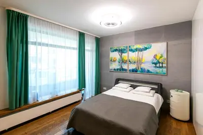a bedroom with a bed and a large window at Apartamenty Lucky 13 in Kraków