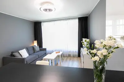 a living room with a couch and a table with flowers at Apartamenty Lucky 13 in Kraków