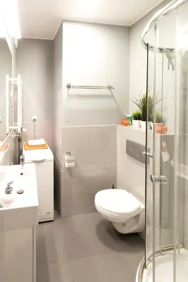 a bathroom with a toilet and a glass shower at Apartamenty Lucky 13 in Kraków