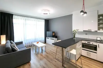 a kitchen and living room with a couch and a table at Apartamenty Lucky 13 in Kraków