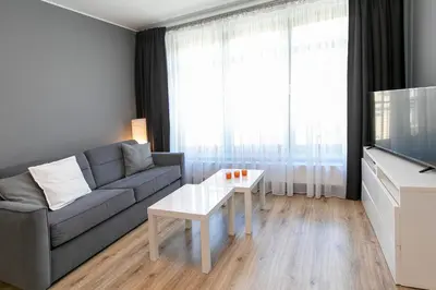a living room with a couch and a tv and a table at Apartamenty Lucky 13 in Kraków