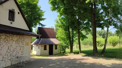a small white building with a brown roof and trees at Zajazd Turystyczny Stara Gawęda in Czechówka