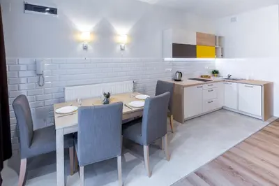 a kitchen with a table and chairs in a kitchen at Arianska Residence in Kraków