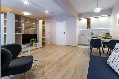 a living room with a table and chairs and a kitchen at Arianska Residence in Kraków