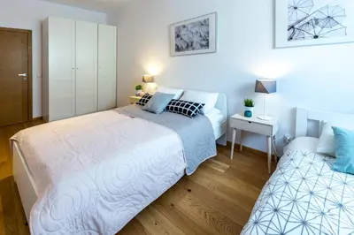 a bedroom with a large bed and a night stand at Arianska Residence in Kraków
