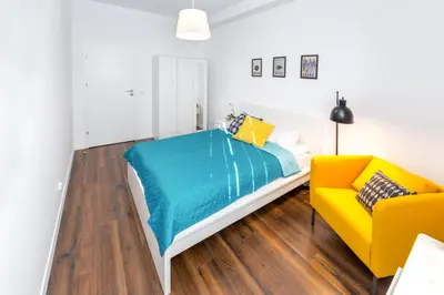 a bedroom with a bed and a yellow couch at Arianska Residence in Kraków