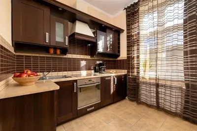 a kitchen with brown cabinets and a bowl of apples on the counter at Caffe latte apartment in Kraków
