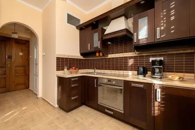 a kitchen with dark brown cabinets and a sink at Caffe latte apartment in Kraków