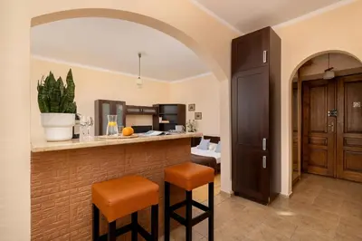 a kitchen with a bar with two stools at Caffe latte apartment in Kraków