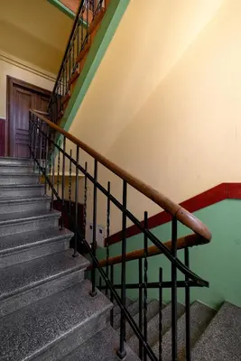 a staircase in an old building with a wooden rail at Caffe latte apartment in Kraków