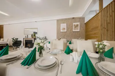 a dining room with a white table with green napkins at Hotel Łaziska in Czchów