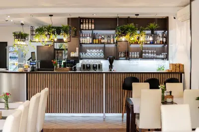a restaurant with a bar with white tables and chairs at Hotel Łaziska in Czchów